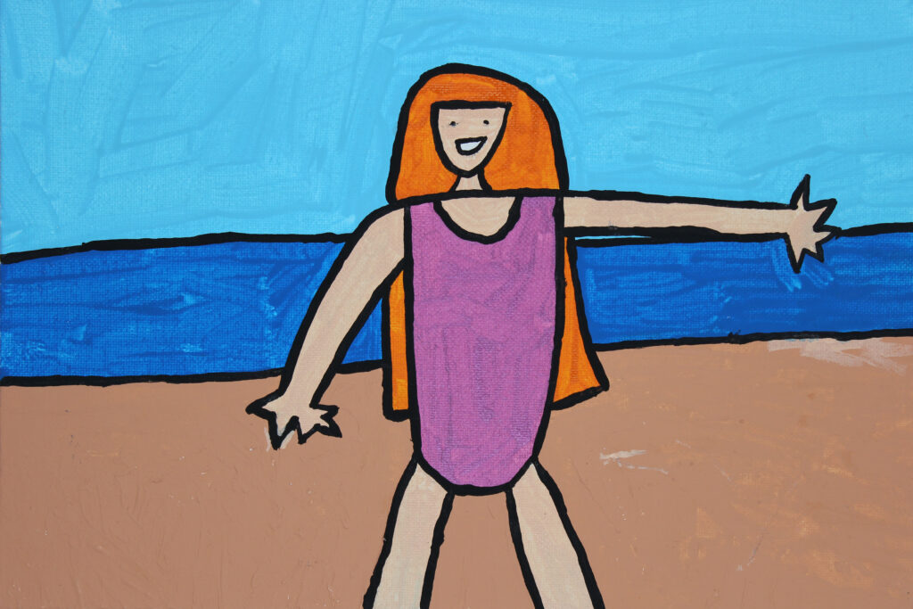 Girl in a pink swimsuit on the beach.